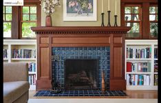 a living room with a fire place and bookshelves on either side of the fireplace