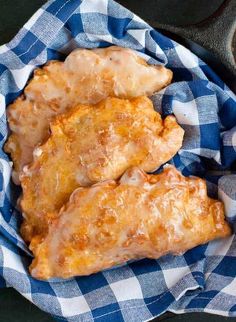 two pieces of chicken sitting on top of a blue and white checkered cloth