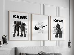 three black and white posters hanging on the wall above a couch in a living room