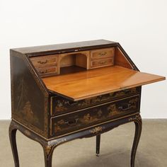 an antique writing desk with drawers on it