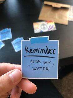 someone is holding up a reminder card with water on it that says reminder drink your water