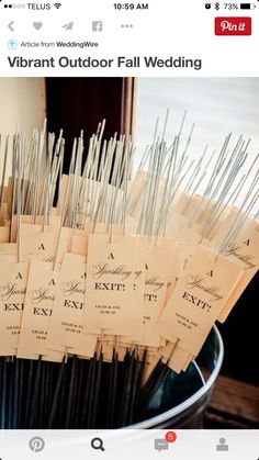 a bunch of tags that are in a bucket on a table with some sticks sticking out of it