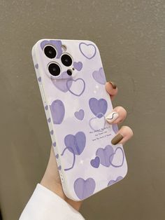 a person holding up a cell phone case with hearts on it and a ring in their left hand