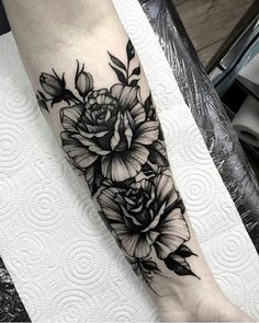 a black and white flower tattoo on the leg