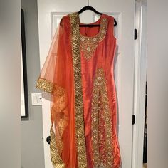 Raw Silk Orange Beaded Sleeveless Suit With Slit. The Pant Leg Is Beaded Which Shoes Through The Slit Of The Top. Half Net Duppata With Latkan. Indian Suit, Sleeveless Suit, Indian Suits, Raw Silk, Midi Dress, Silk, Womens Dresses, Orange, Pants