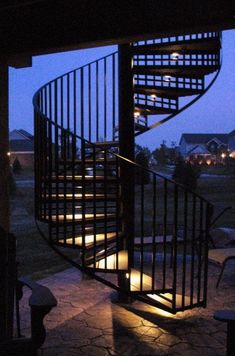 a spiral staircase lit up at night