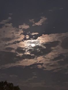 the moon is shining brightly in the cloudy sky