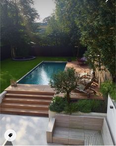 an outdoor pool with steps leading up to it and trees in the backround