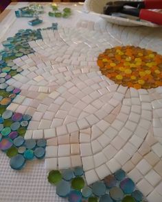 a table topped with lots of different types of glass mosaics on top of it