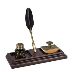 a pen and quill sitting on top of a wooden stand with writing utensils