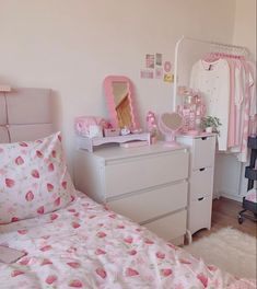 a bedroom with pink and white decor on the walls, bedding and dressers