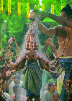 two men are pouring water on a statue