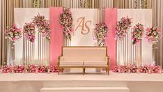 a white couch sitting in front of a wall with pink flowers on it's sides