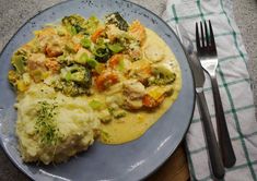 a blue plate topped with mashed potatoes and broccoli