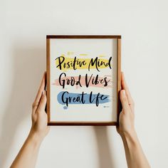 someone holding up a framed poster with the words positive mind good vibes great life