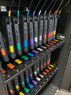 many different colored toothbrushes are on display in a store shelf with black metal shelving