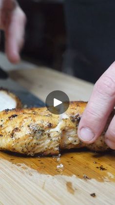 a person is cutting up some food on a wooden board