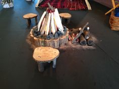 an outdoor fire pit made out of logs and logs with wood shavings around it