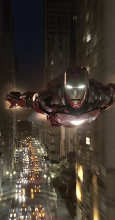 an iron man flying through the air over a city at night with lots of traffic