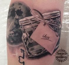 a tattoo with an image of two jars and a tag on it