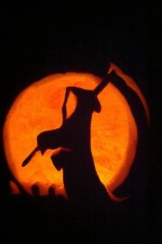 a silhouette of a giraffe holding a knife in front of a full moon