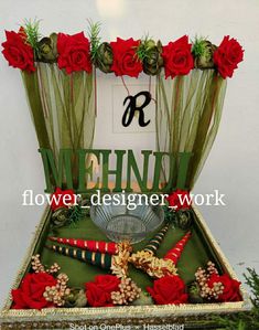 a metal tray with flowers and other items in front of a sign that reads r