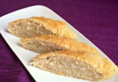 two pieces of bread sitting on top of a white plate next to a purple cloth