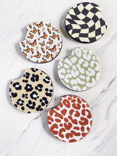 four animal print coasters on a marble surface