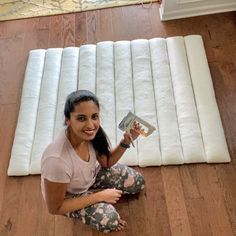 a woman is sitting on the floor with her book in front of some mattresses