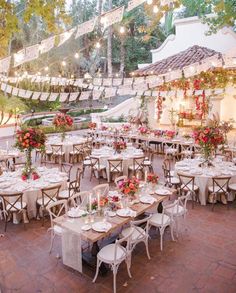 an outdoor dining area with tables and chairs set up for a formal dinner or party