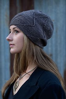 a woman with long hair wearing a knitted hat and looking off into the distance