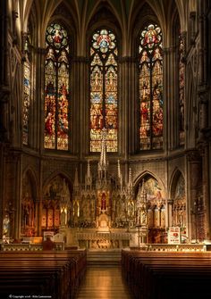 the inside of an old church with stained glass windows and pews on both sides