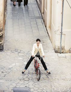 a man is sitting on top of a bike in the middle of an alleyway