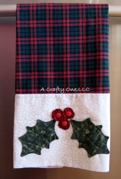 two christmas decorations hanging from the side of a door with red and green plaid fabric