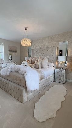 a bedroom with a large bed and white fur rugs on the floor in front of it