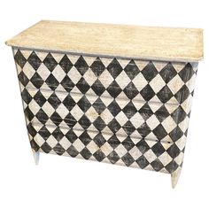 a black and white checkerboard chest with drawers on one side and an open drawer on the other