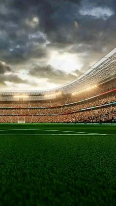 an empty soccer stadium filled with fans and players during the day time, under cloudy skies