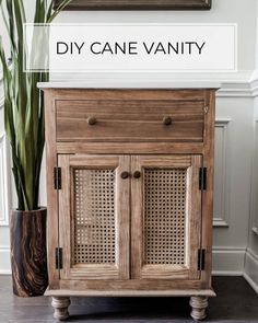 a wooden cabinet sitting next to a potted plant