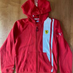 Ferrari + Puma Boys Hooded Zip Up Sweatshirt. Size Large. Ferrari Logo And Scuderia Ferrari On The Hood. New With Tags Attached. Smoke Free Home. Red Long Sleeve Sports Hooded Jacket, Red Long Sleeve Hooded Jacket For Sports, Red Long Sleeve Hooded Sports Jacket, Red Fleece Hooded Sports Jacket, Red Fleece Sporty Hooded Jacket, Red Sporty Fleece Hooded Jacket, Red Crew Neck Sportswear Outerwear, Red Sporty Cotton Hooded Jacket, Sporty Red Cotton Hooded Jacket