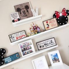 some shelves with pictures and mickey mouse magnets on them in a child's room