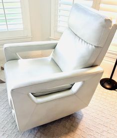 a white recliner chair sitting in front of a window