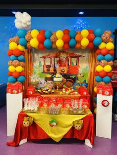 a table topped with lots of food and balloons