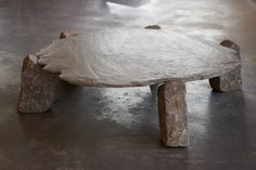 a table made out of rocks sitting on top of a cement floor