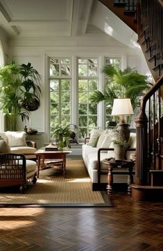 a living room filled with lots of furniture and plants on the windows sills