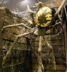 a large spider statue sitting on top of a wooden wall