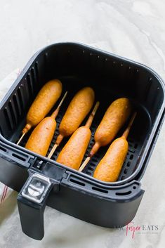 four chicken skewers sitting in an air fryer on top of a table