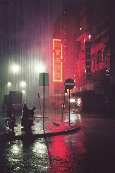 a person standing in the rain at night with an umbrella over their head and lights on