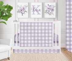 a baby's room with purple and white checkered wallpaper, two framed monogrammed pictures on the wall