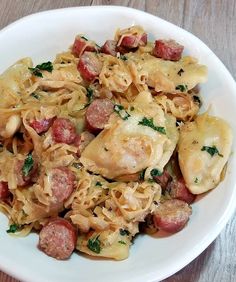 a white bowl filled with pasta and sausage