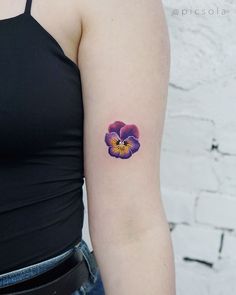 a woman's arm with a flower tattoo on the left side of her arm